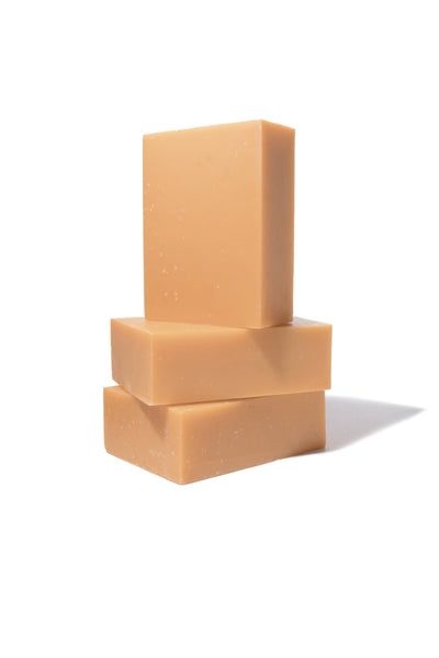 
                    
                      Geranium bar soap, three stacked light brown olive oil bars, natural texture, side view.
                    
                  