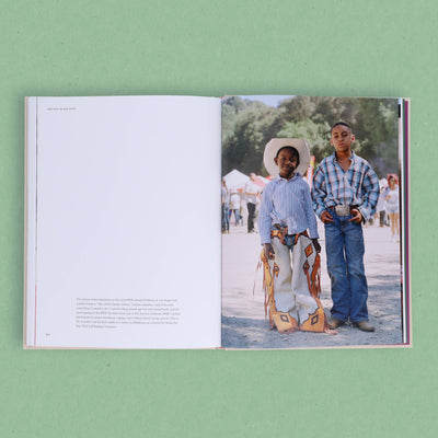 
                    
                      The New Black West book, open showing interior text and a full-color photo of two young Black boys in rodeo chaps, plaid…
                    
                  
