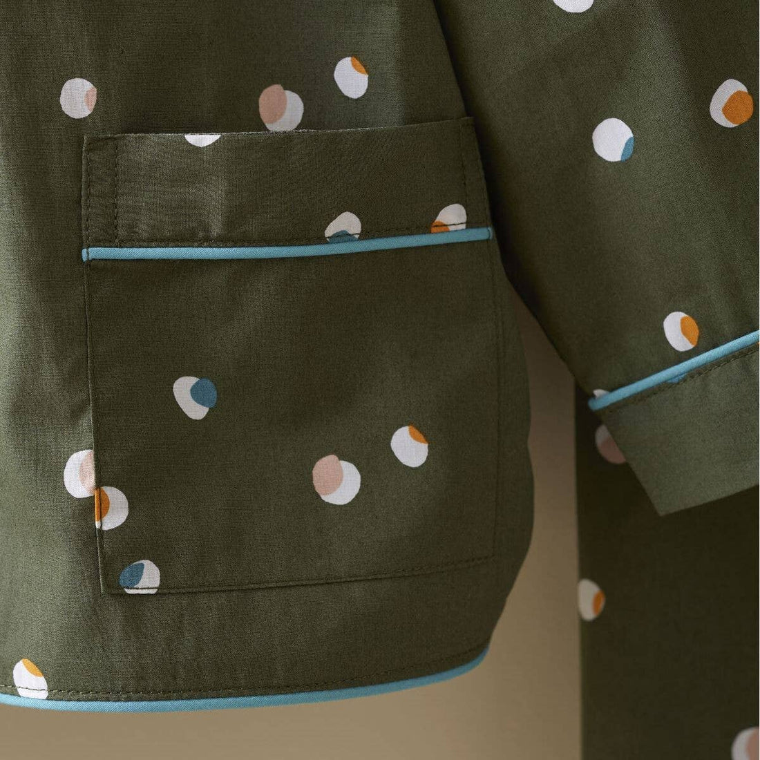 Kids Confetti Pajamas, olive green cotton with multicolor confetti dots, close-up of chest pocket, hem, and sleeve with…