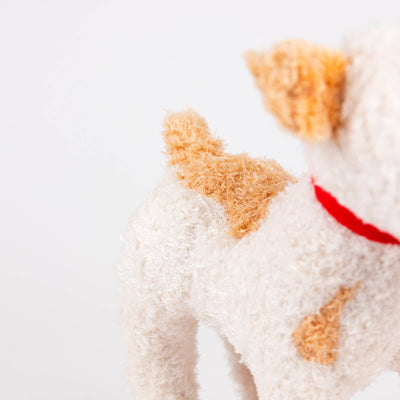 
                    
                      Eliot Dog plush pull-along toy, cream and tan polyester plush with red collar, close-up view of back and fluffy tail.
                    
                  