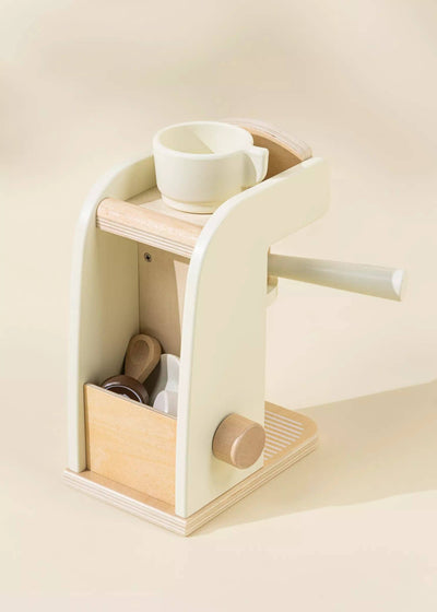 
                    
                      Wooden Coffee Maker Set play kitchen toy, light cream and natural pine wood, 3/4 front view showing the coffee mug and scoop.
                    
                  