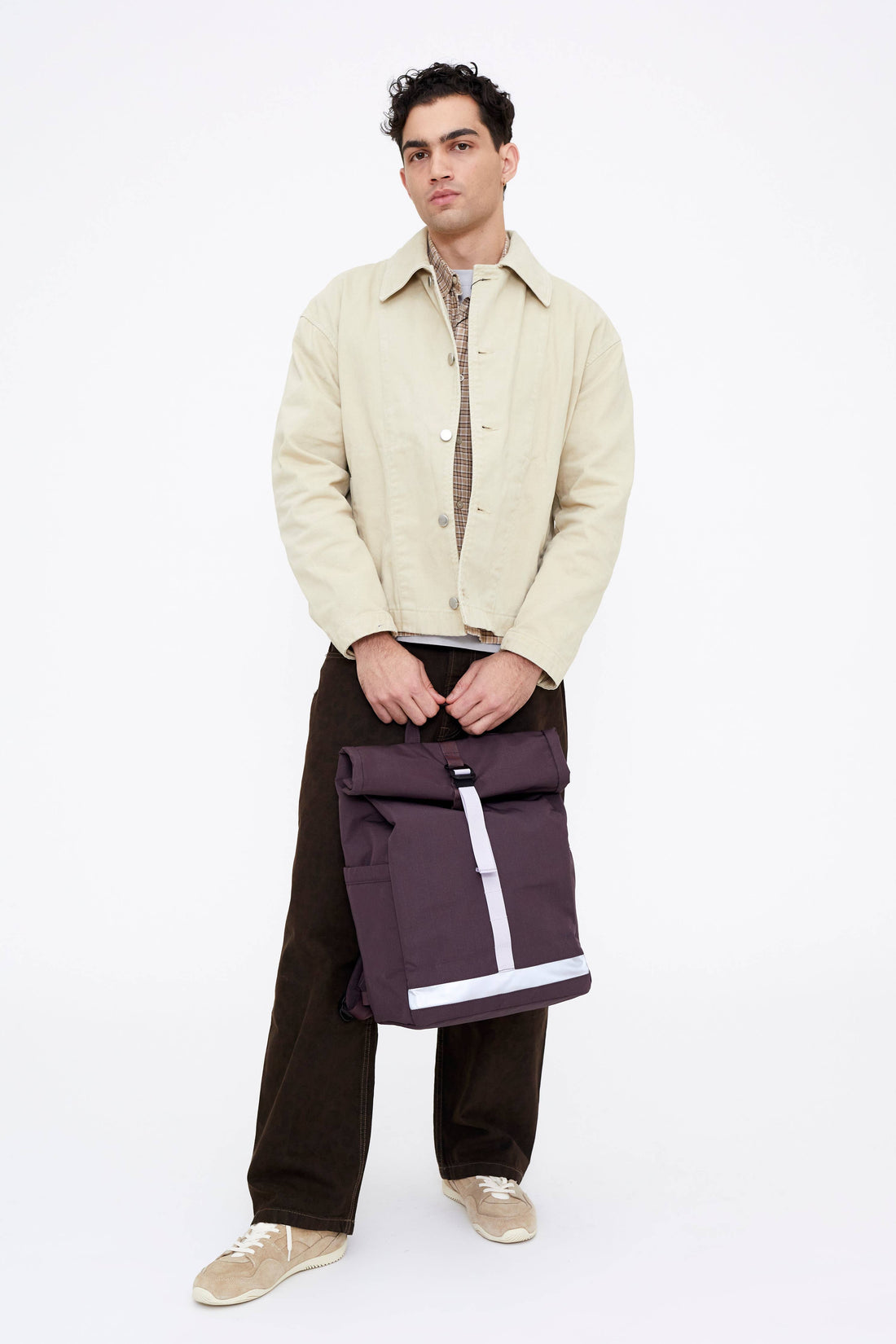 Lefrik Lars Roll backpack, Wine color, held by male model, showing roll-top closure and reflective band.