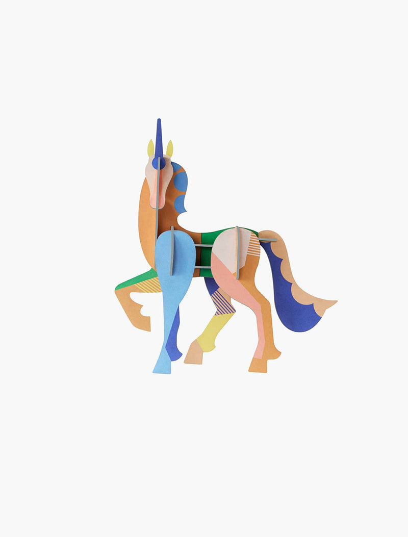 Studio Roof 3D Unicorn craft kit, assembled multicolor recycled cardboard figure with geometric patterns, front view on…