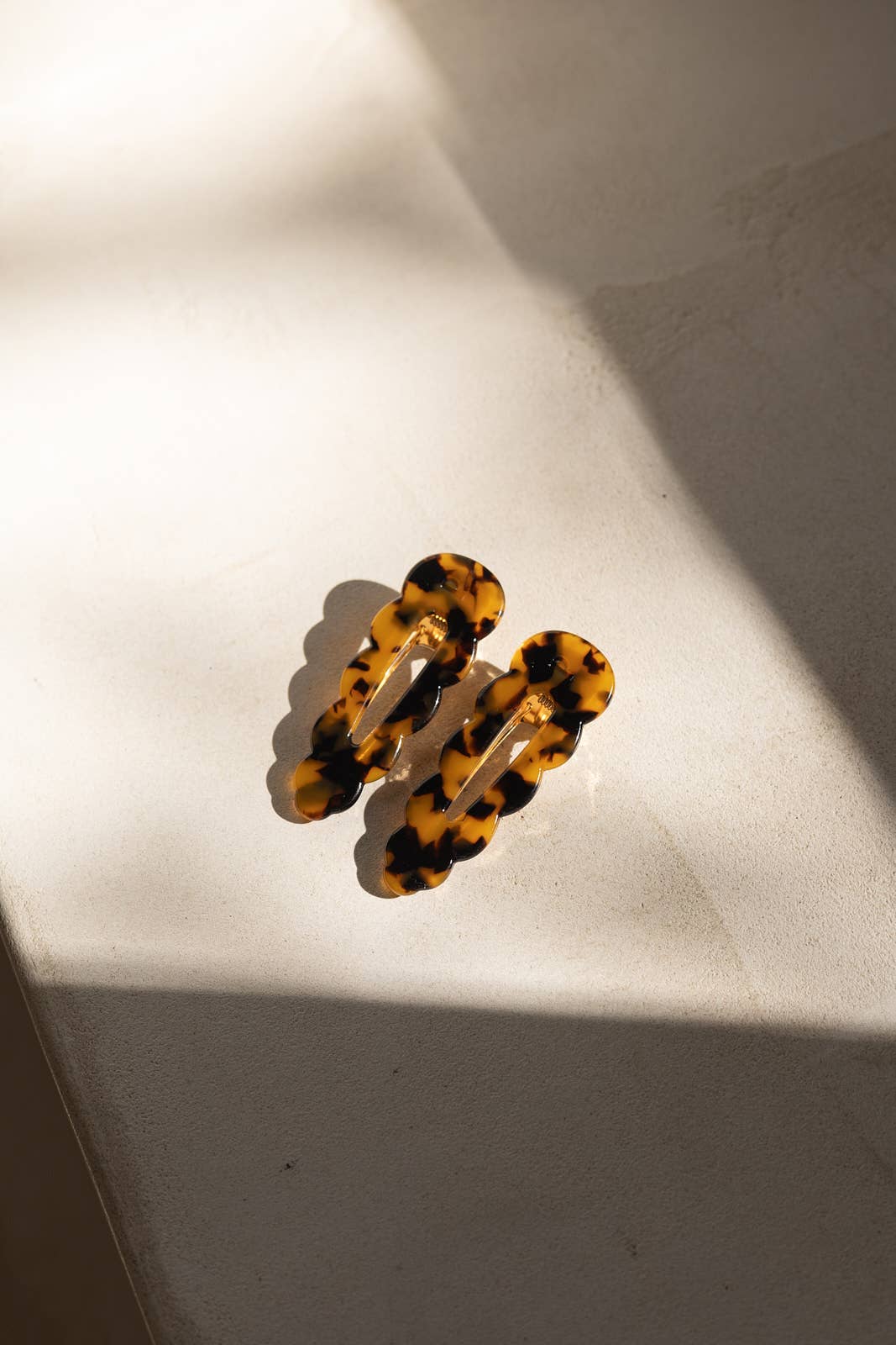 Signature hair clips, two tortoise cellulose acetate clips, angled flat lay showing metal clasps.
