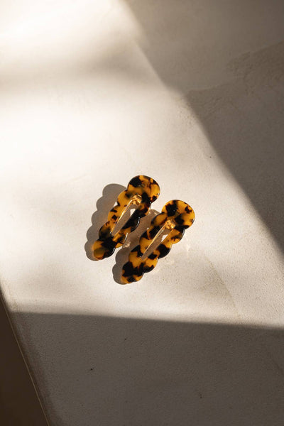 
                    
                      Signature hair clips, two tortoise cellulose acetate clips, angled flat lay showing metal clasps.
                    
                  