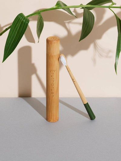 
                    
                      Truthbrush Moss Green Bamboo Toothbrush with white bristles, propped against its natural bamboo travel case.
                    
                  