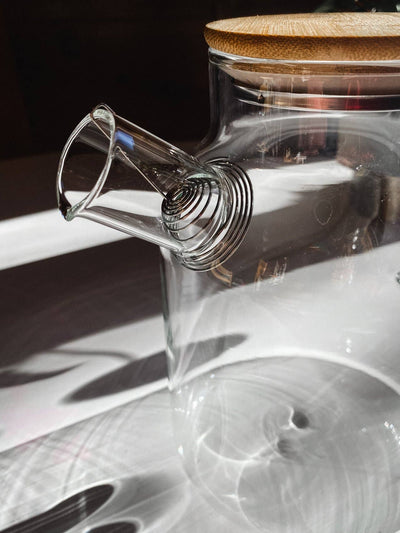 
                    
                      Heat-Resistant Glass Teapot, close-up of clear borosilicate glass spout with stainless steel coiled infuser and bamboo lid.
                    
                  
