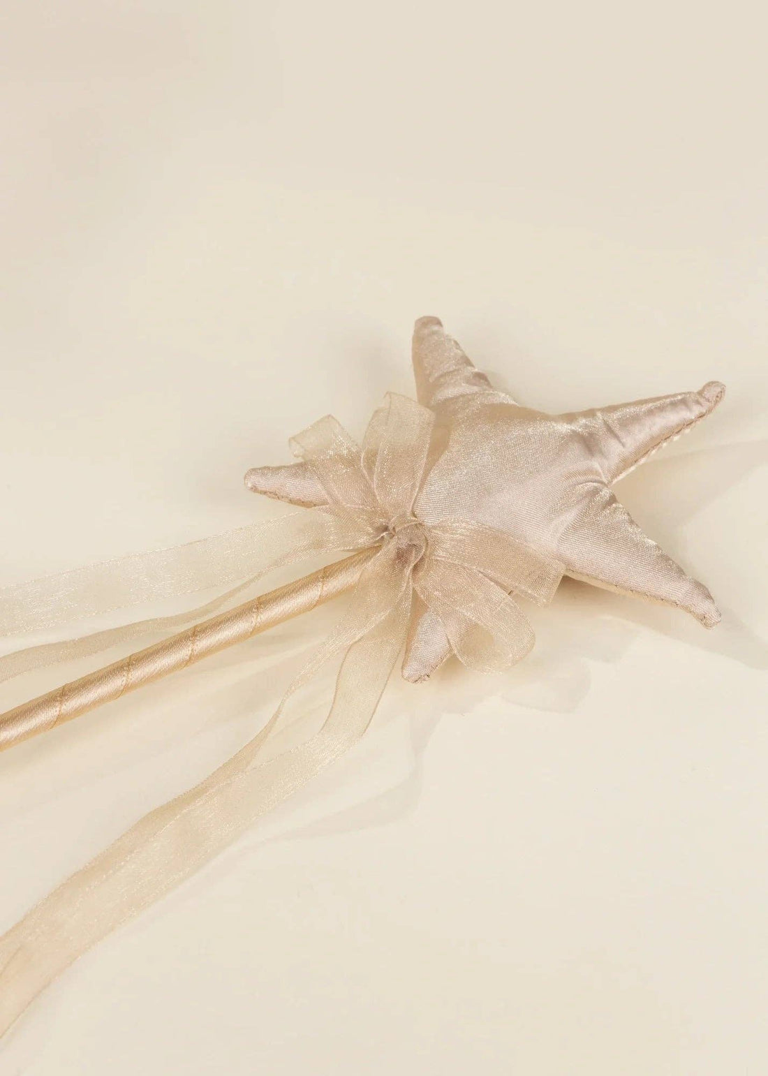 Gold Star Wand play wand, shimmery gold fabric star and sheer gold ribbon handle, close-up angled view.