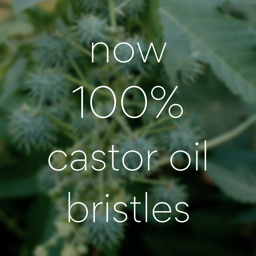 Moss Green Bamboo Toothbrush: 'now 100% castor oil bristles' on a blurry green castor plant background.