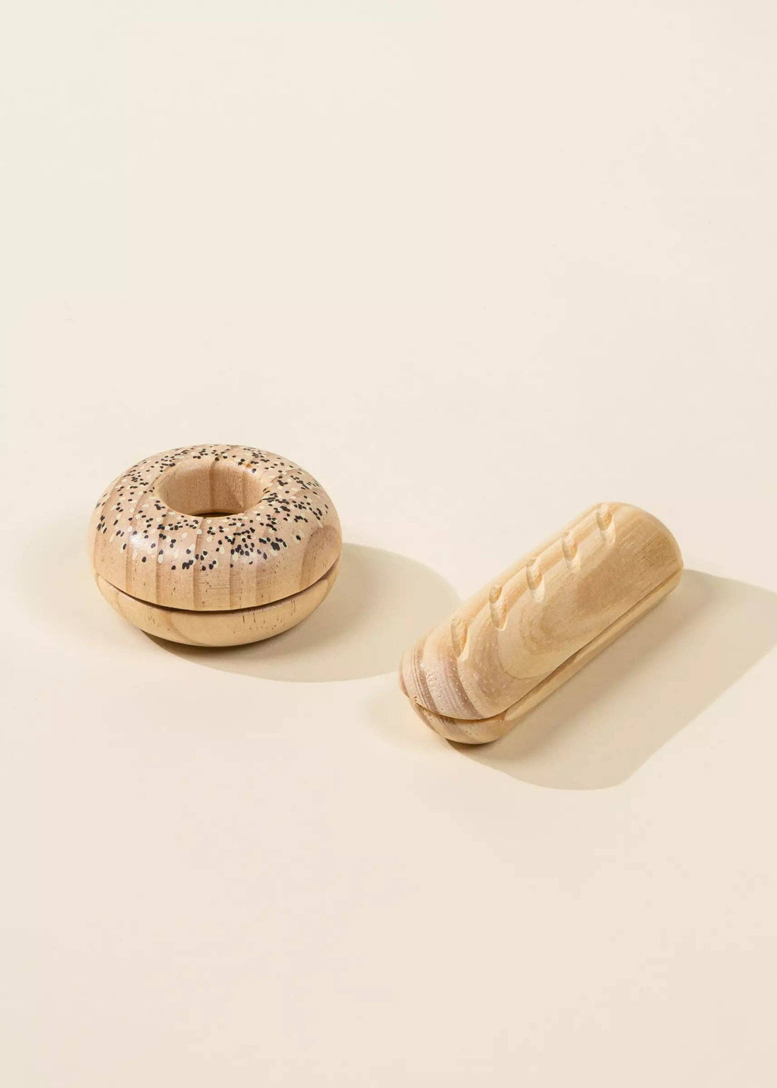 Wooden Bakery Set toys: bagel with black & white sesame seeds & carved baguette, displayed side by side.