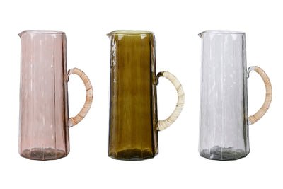 
                    
                      Hammered Glass Pitchers, a trio in rose, olive green, and clear handblown glass with rattan handles, side-by-side.
                    
                  