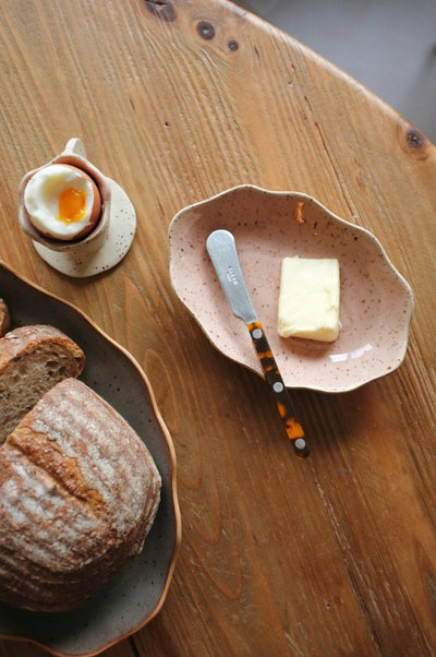 
                    
                      Handcrafted Stoneware Tray, speckled light pink stoneware, overhead view showing its use for butter and a knife.
                    
                  