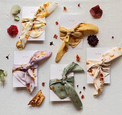 
                    
                      Eucalyptus Grove silk bandana scarf, pale sage green leaf, tied on card. Flat lay with other variants.
                    
                  