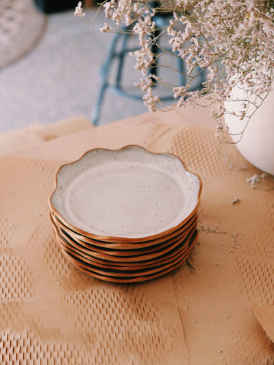 
                    
                      Handcrafted Stoneware Plates, stack of six showing speckled off-white surface and terracotta scalloped rims.
                    
                  
