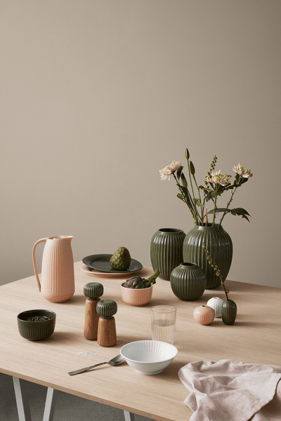 
                    
                      Hammershøi spice grinders, oiled oak with dark green porcelain tops, pair on a light wood dining table with ground salt.
                    
                  