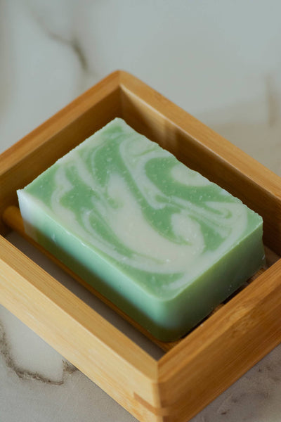 
                    
                      Moso Bamboo Soap Shelf, light natural bamboo, close-up angled view with green and white swirled soap.
                    
                  