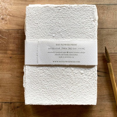 
                    
                      Bat Flower Press Ivory Handmade Paper Set, textured recycled cotton paper with raw edges, flat lay showing brand band and…
                    
                  