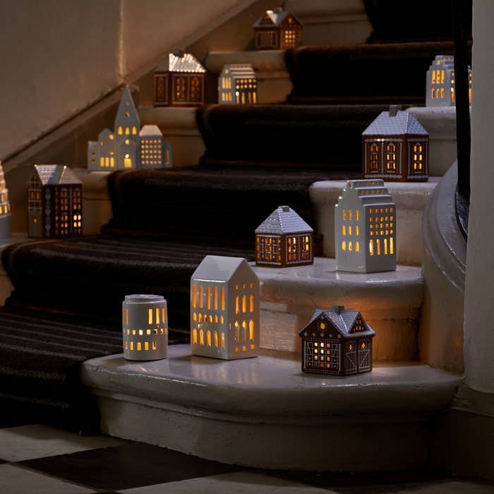 Urbania Ceramic Lighthouse candle holders, including Church model, glowing on a dark staircase.