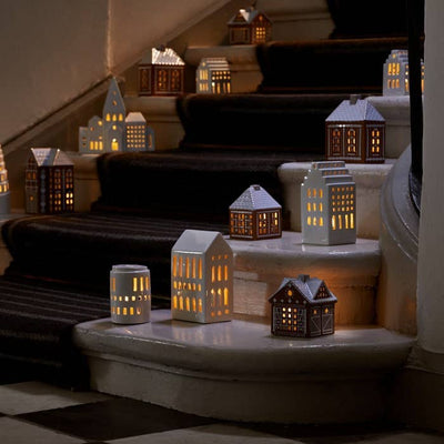 
                    
                      Urbania Ceramic Lighthouse candle holders, including Church model, glowing on a dark staircase.
                    
                  