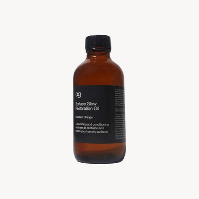 
                    
                      Surface Glow Restoration Oil, brown glass bottle with black cap, black label with Mandarin Orange scent, angled front view.
                    
                  