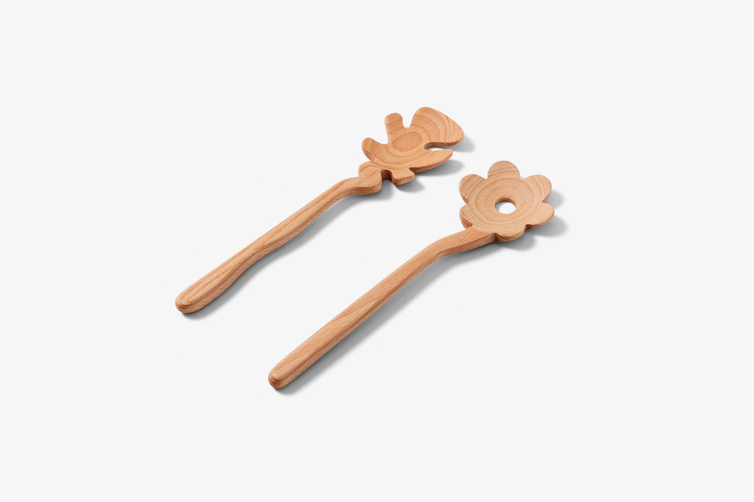 Serving Friends wooden serving utensils, light beech wood, angled overhead view of the flower and abstract person shapes.