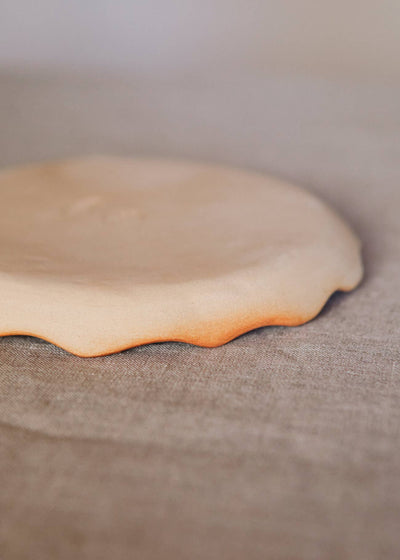 
                    
                      Handcrafted Stoneware Plate, close-up of organic wavy rim, natural light stoneware with reddish-brown fired edge.
                    
                  