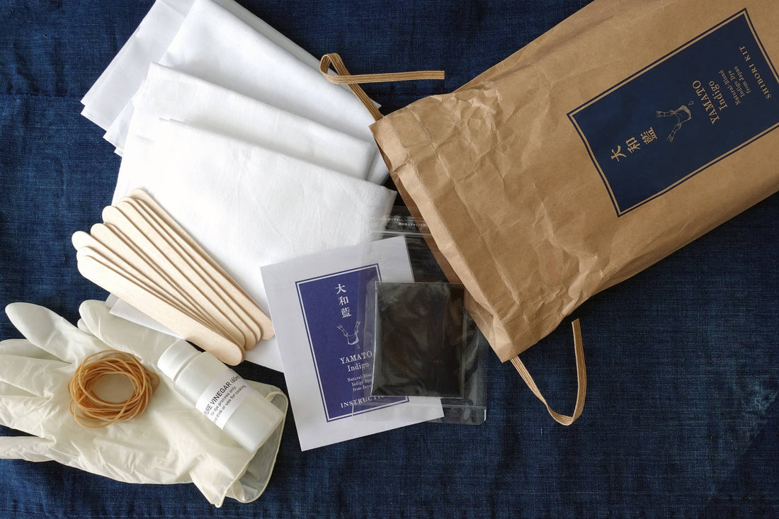 Yamato Indigo Shibori Kit, all contents flat lay: white cotton textiles, indigo dye packet, wood sticks, rubber bands,…