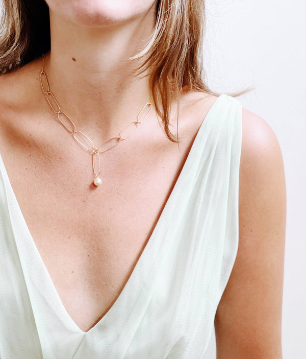 Nest Pretty Things Paperclip And Pearl necklace, gold paperclip chain with single pearl drop, on model décolletage.