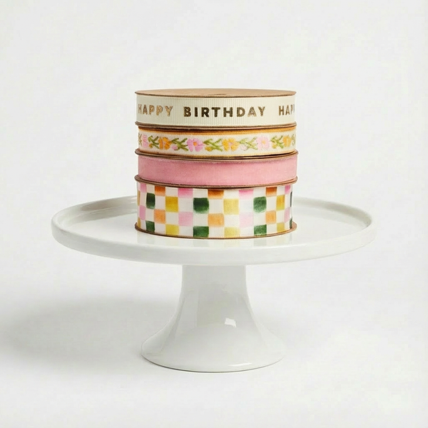 Abigail Jayne Design Happy Birthday and Celebration Ribbons, 4 spools stacked, gold text, floral, pink, checkered patterns.