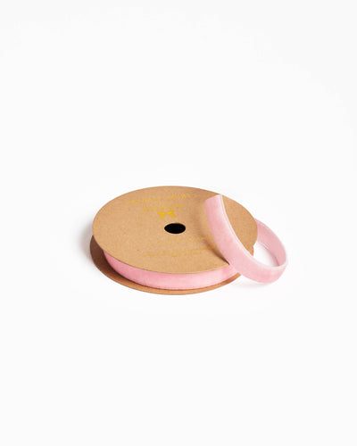 
                    
                      Spool of pink ribbon on a cardboard reel with a white background
                    
                  