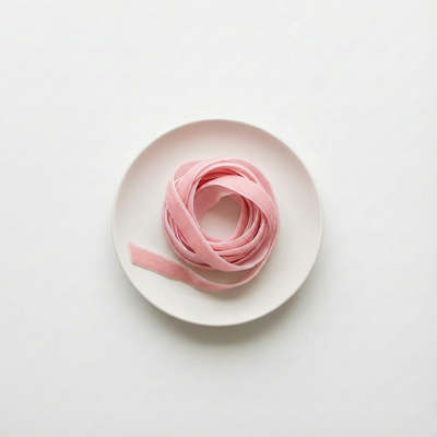 
                    
                      Pink ribbon on a white plate against a light gray background
                    
                  