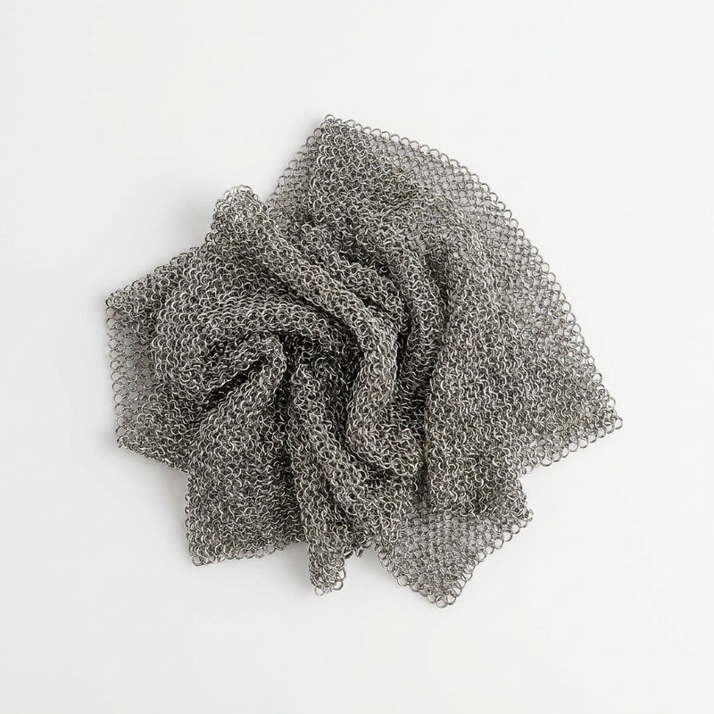 Barebones Stainless Steel Cleaning Mesh, textured chainmail crumpled in a pile, flat lay on white.