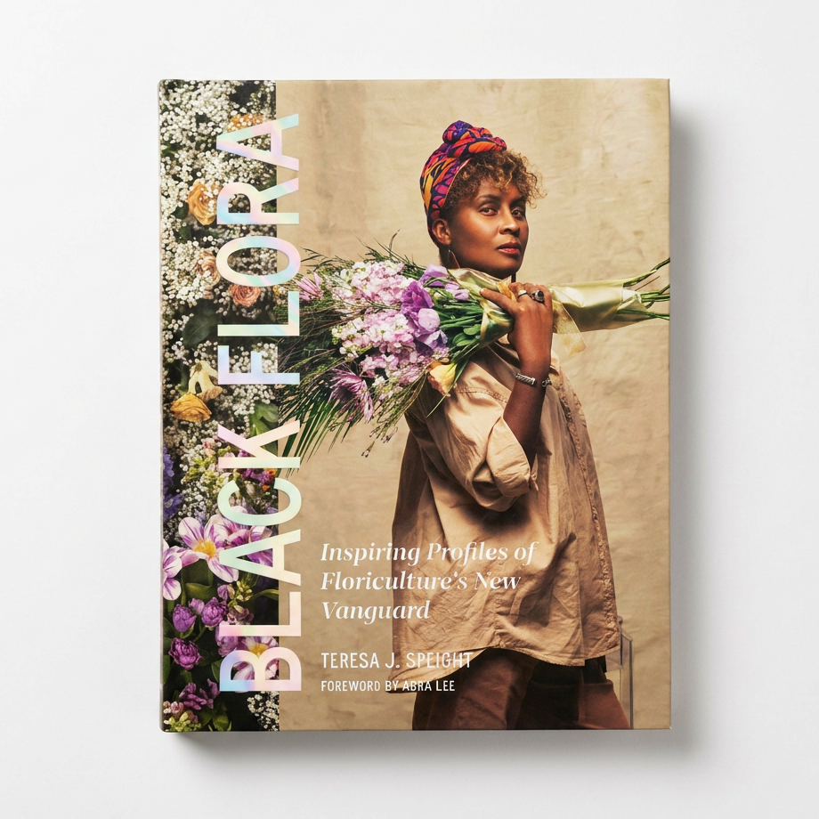 Hachette Book Group Black Flora hardcover book, iridescent title, vibrant floral cover with woman in headwrap, front view on…