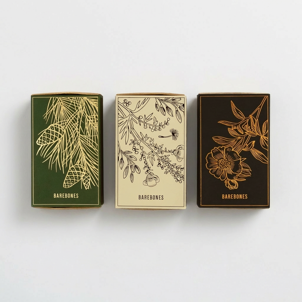 Barebones Botanical Matches, matchboxes in green, cream, and dark brown with gold and black botanical illustrations, front…