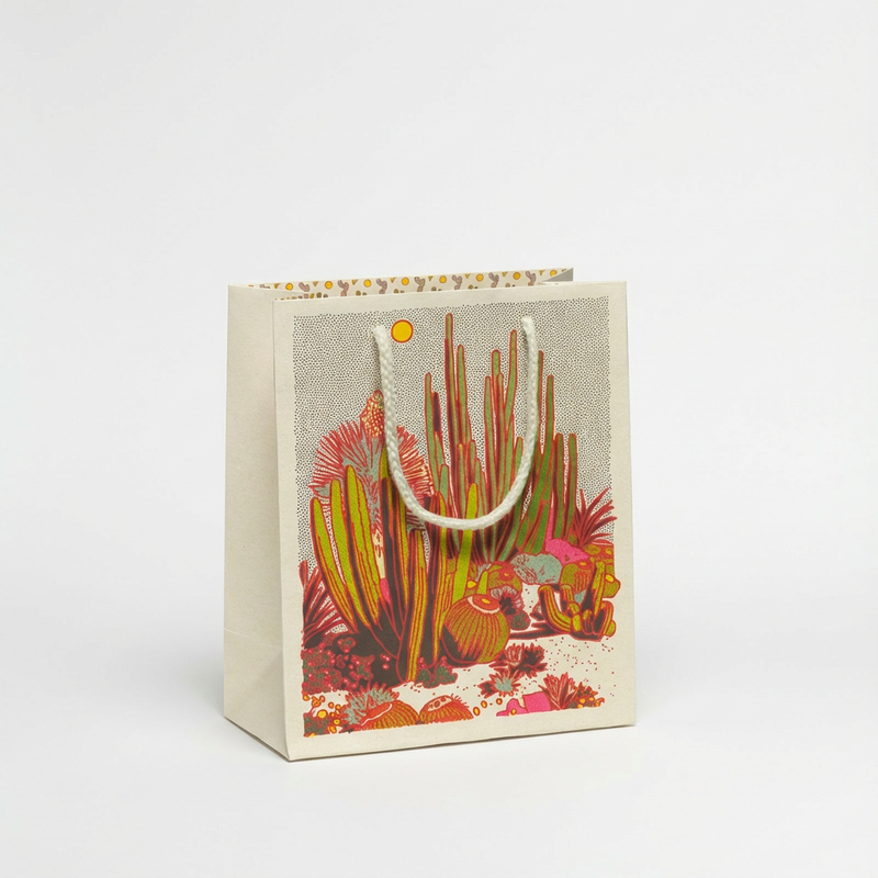 Red Cap Cards Cactus Scene gift bag, red, green, yellow, pink cactus design on light paper, white rope handles, front view.