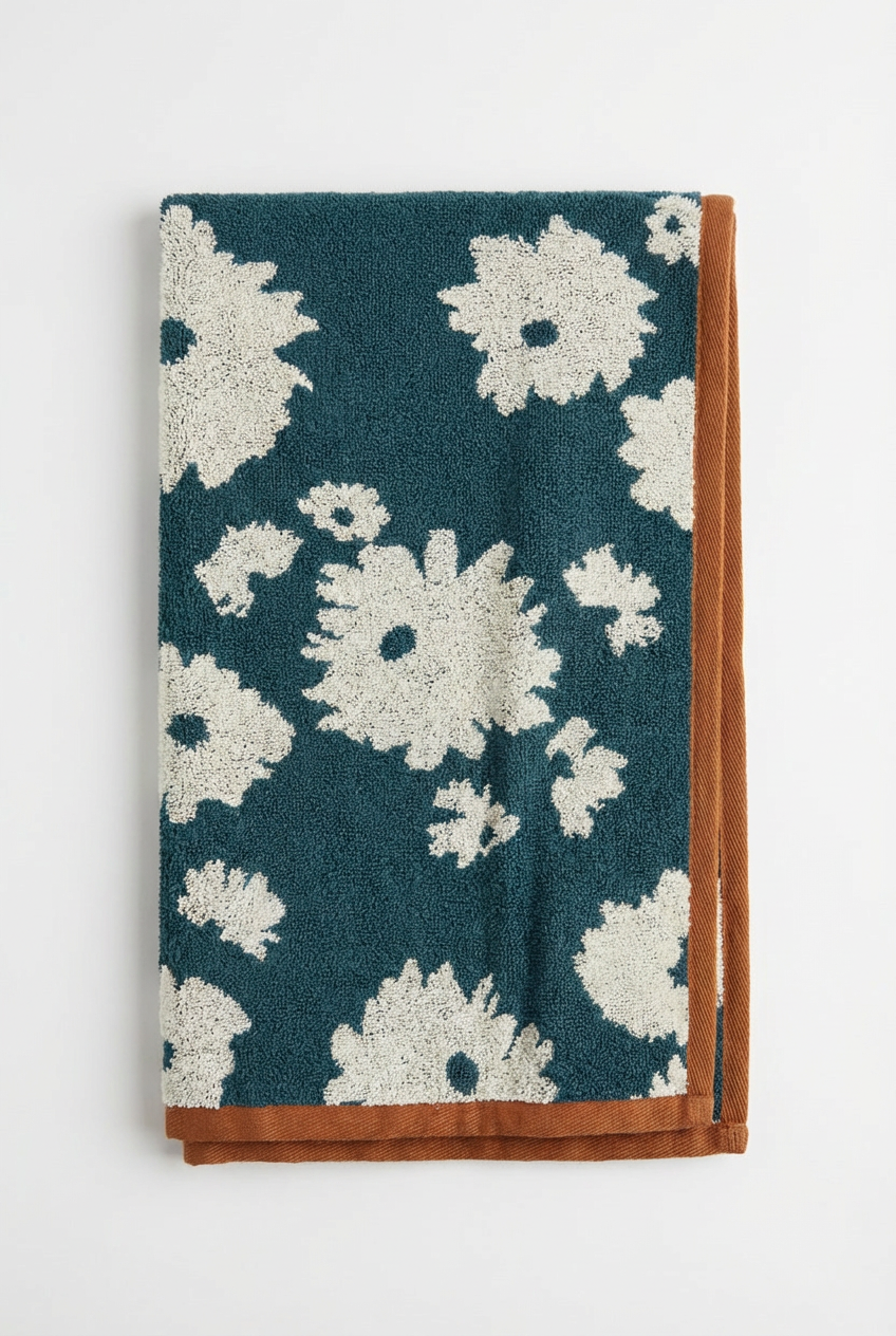 Floral patterned towel with white flowers on a teal background