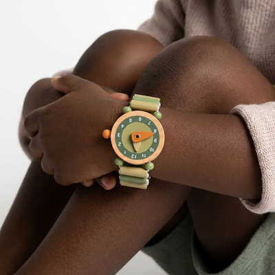 
                    
                      Raph wooden watch, natural wood & olive green elastic strap, dark green numbers, worn on child's wrist.
                    
                  