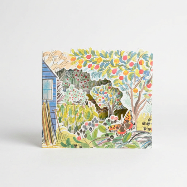 Art Angels Orchard Allotment die-cut card by Emily Sutton, layered garden scene with blue shed, fruit trees, butterfly on…