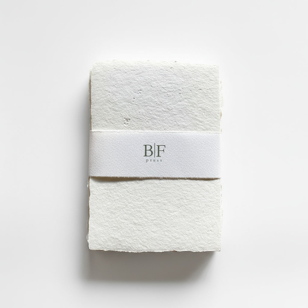 Bat Flower Press Ivory Handmade Paper Set, stack of ivory recycled cotton paper sheets, wrapped with branded band, front on…
