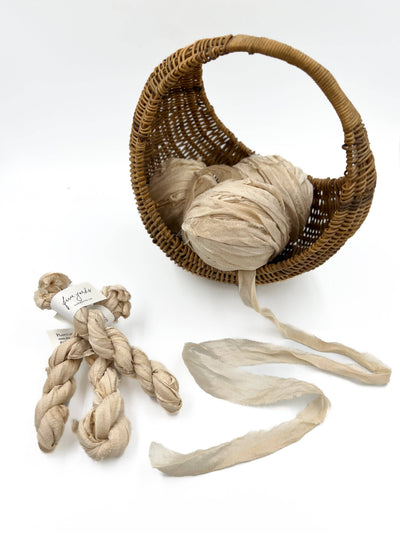 
                    
                      Farmette Plant-Dyed Sari Silk Ribbon, Lace off-white bundles in a woven basket and with product tag, unspooled length…
                    
                  
