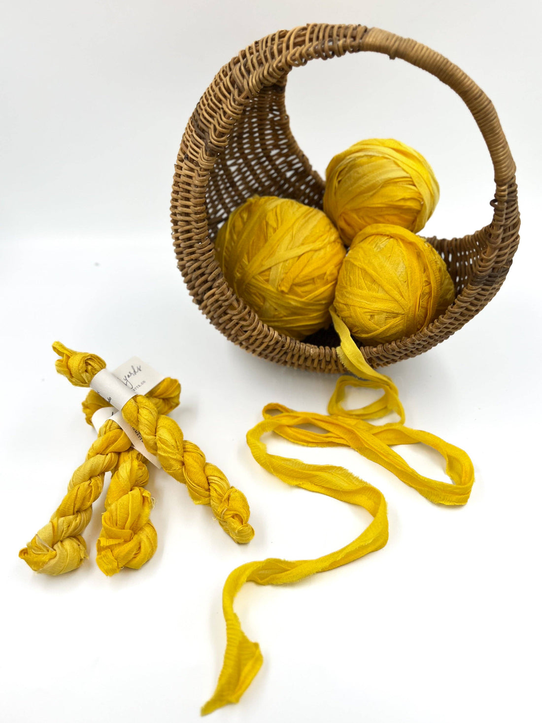 Plant-Dyed Sari Silk Ribbon, Sunflower yellow, recycled silk shown balled in a basket, braided with label, and unwound.