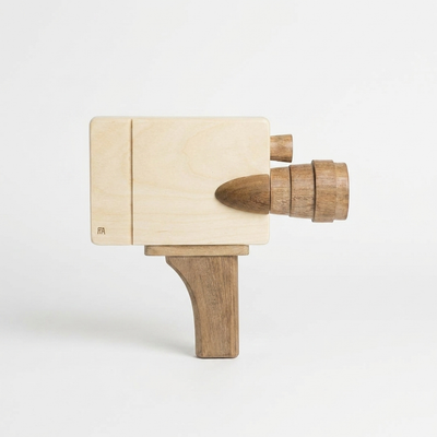 
                    
                      Pretend Film Camera wooden toy camera, light rubber wood body with darker sapele teak lens and handle, angled side view.
                    
                  
