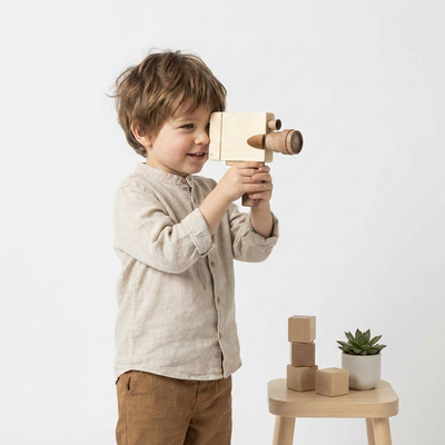 
                    
                      Pretend Film Camera wooden toy camera, light rubber wood body and darker Sapele teak lens, held by a child looking through…
                    
                  