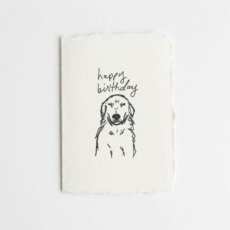 White letterpress card with a black line drawing of a golden retriever and 'happy birthday' text on a white background