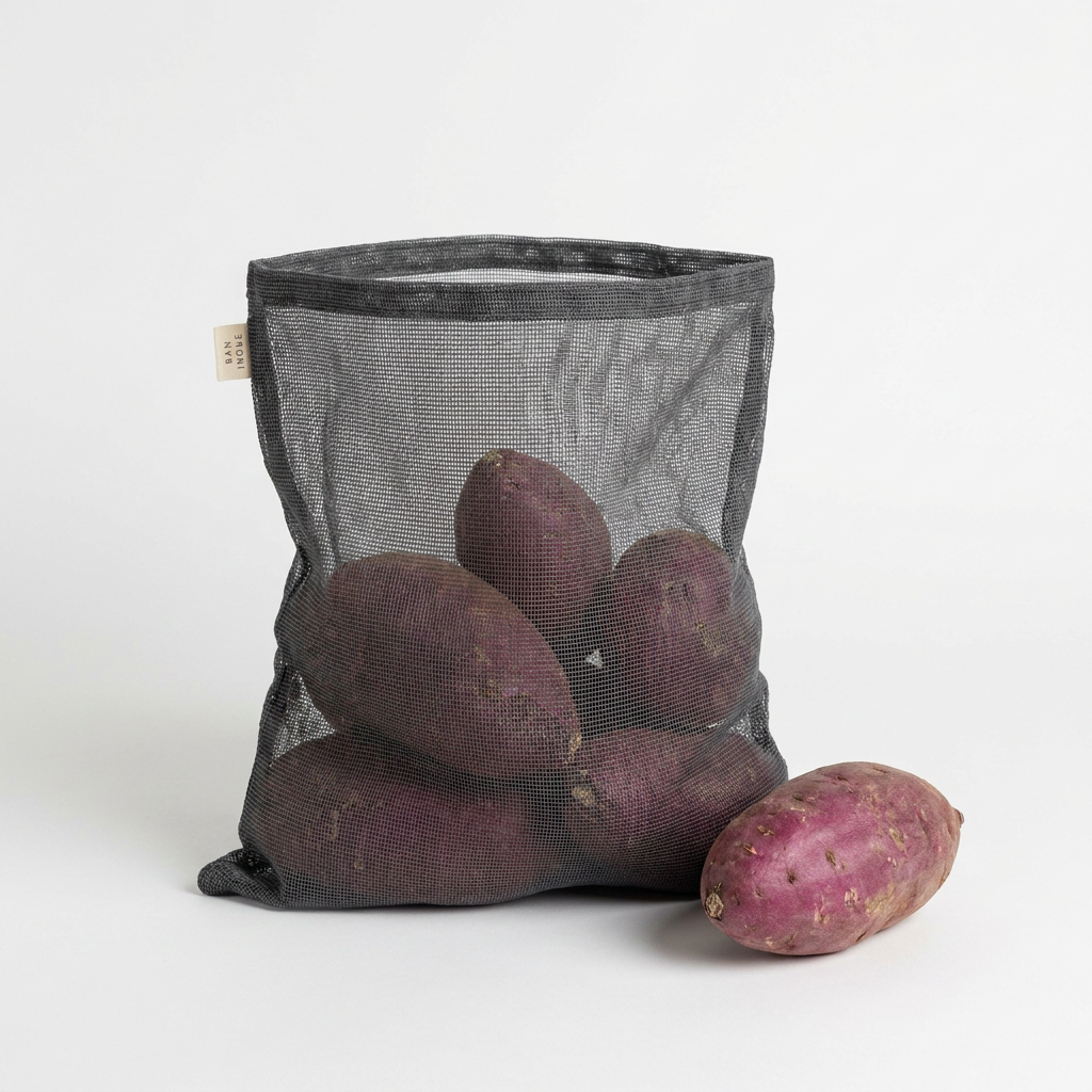 Ban Inoue Japanese Cotton Gauze Storage Bag, dark gray mesh, filled with purple sweet potatoes, one potato outside.