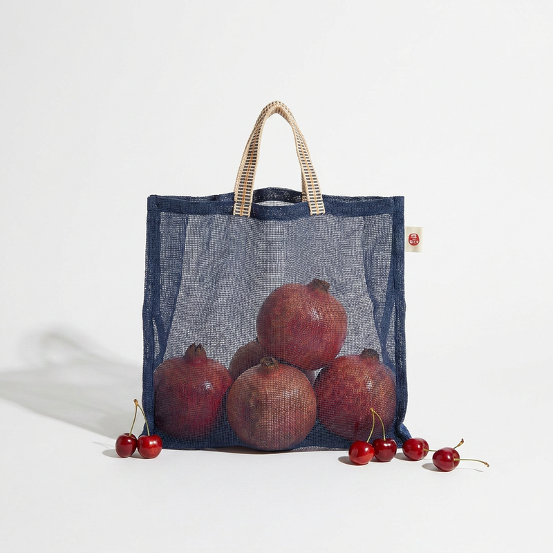 Ban Inoue Japanese Cotton Gauze Produce Bags, navy blue with woven striped ribbon handle, filled with pomegranates, front on…