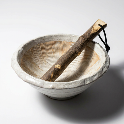 
                    
                      Rustic Japanese Ceramic Mortar, white Kohiki ceramic with textured, ridged interior. Natural wood pestle resting inside,…
                    
                  