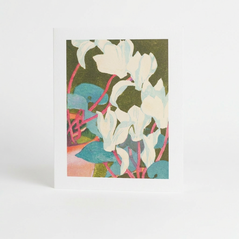 Art Angels Cyclamen Greeting Card by Mabel Royds, white flowers, teal leaves, pink stems on dark green, front view.