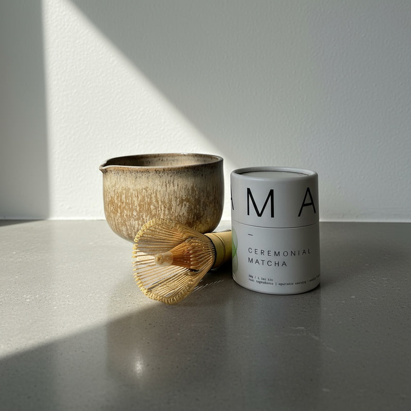 Katie + Kin Mindful Matcha Set: textured ceramic matcha bowl, bamboo whisk, and white Ceremonial Matcha tin, front view.