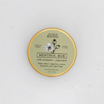 
                    
                      Menthol Rub 2 oz tin, light green label with black & white floral illustration, top-down close-up view.
                    
                  